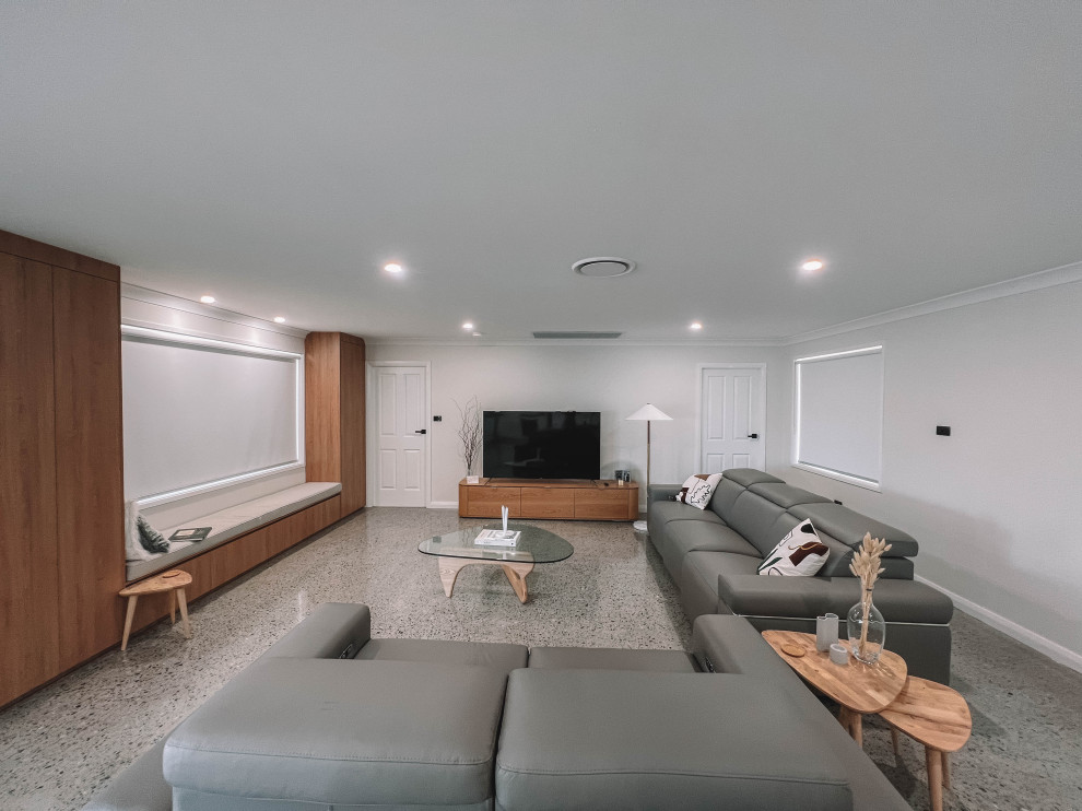 На фото: открытая гостиная комната среднего размера в скандинавском стиле с белыми стенами, бетонным полом, отдельно стоящим телевизором, серым полом, деревянным потолком и деревянными стенами с