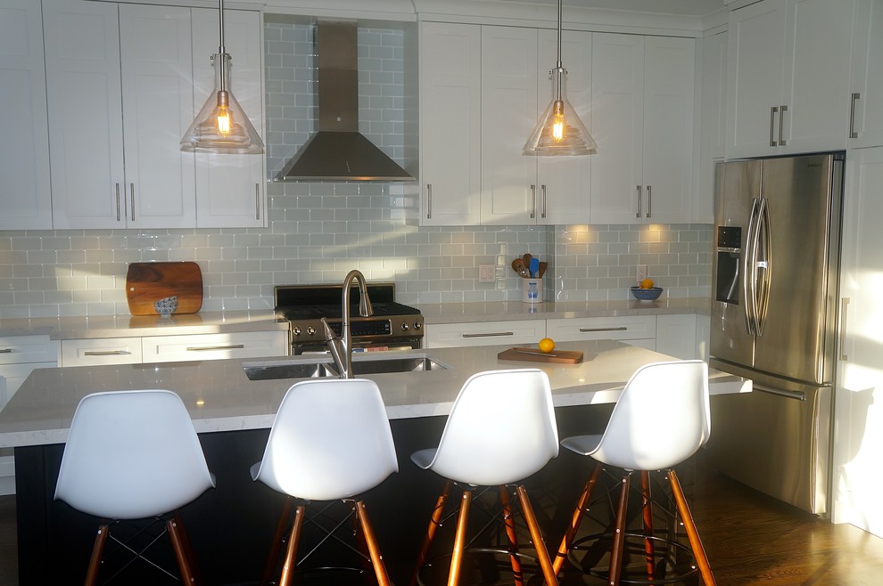 Transitional galley dark wood floor kitchen photo in Toronto with an undermount sink, shaker cabinets, white cabinets, quartz countertops, blue backsplash, glass tile backsplash, stainless steel appliances and an island