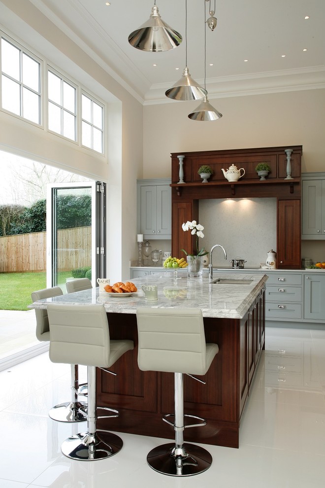 Large transitional kitchen in Hertfordshire with shaker cabinets, with island, a double-bowl sink and blue cabinets.