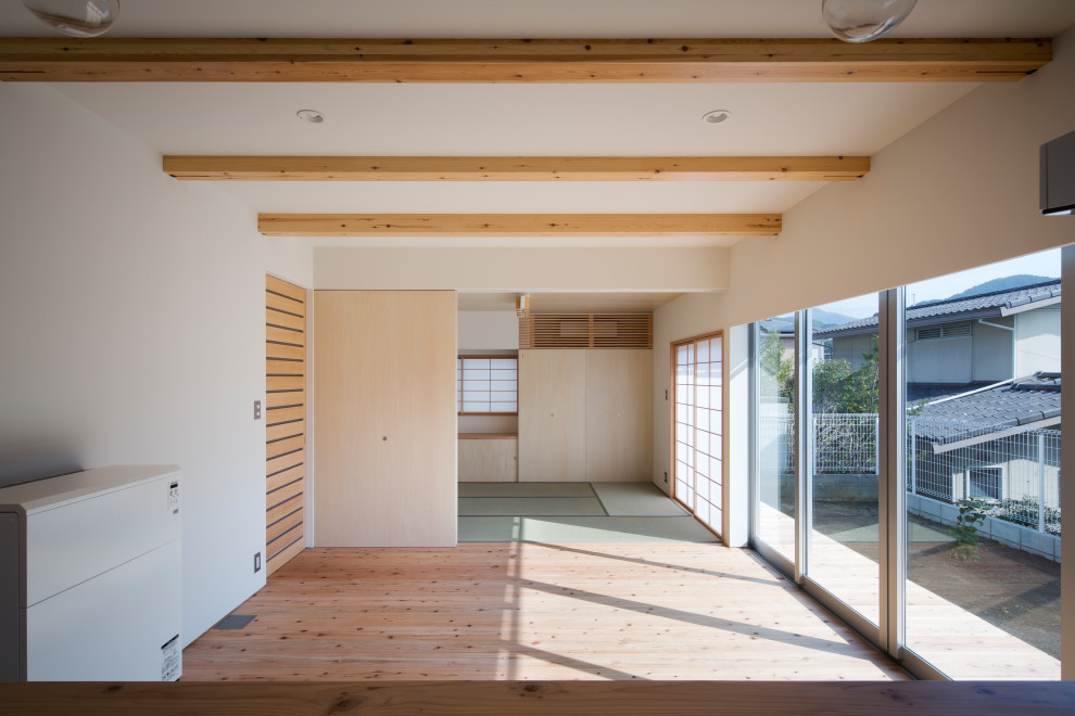 Wohnzimmer mit weißer Wandfarbe, braunem Holzboden, beigem Boden, Tapetendecke und Tapetenwänden in Sonstige