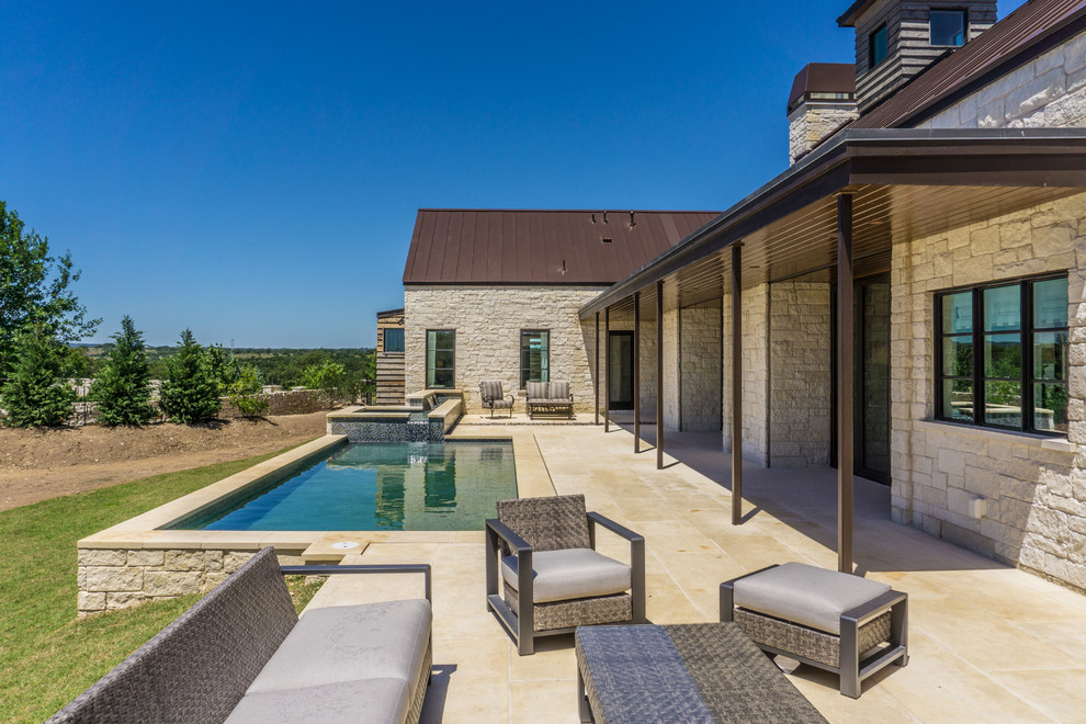 Design ideas for a large country backyard rectangular pool in Austin with a hot tub and concrete pavers.