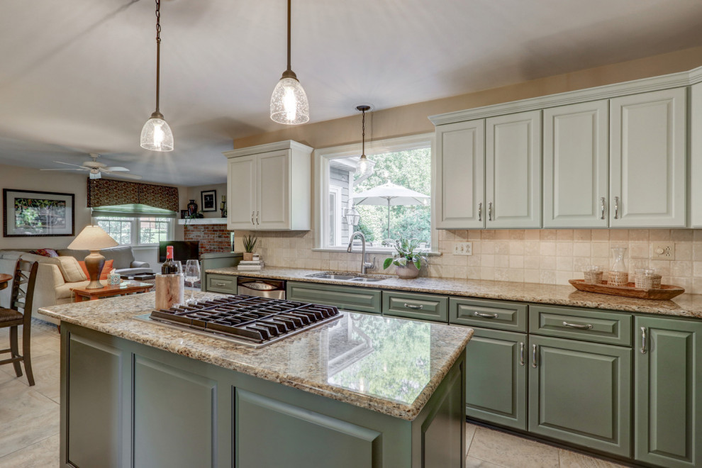 Inspiration for a mid-sized transitional l-shaped ceramic tile and beige floor eat-in kitchen remodel with a double-bowl sink, raised-panel cabinets, green cabinets, granite countertops, beige backsplash, ceramic backsplash, stainless steel appliances, an island and beige countertops