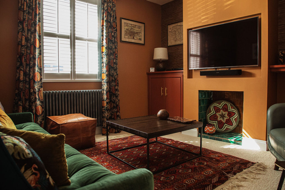 На фото: гостиная комната в стиле фьюжн с оранжевыми стенами, ковровым покрытием, фасадом камина из плитки, белым полом, обоями на стенах и красивыми шторами с