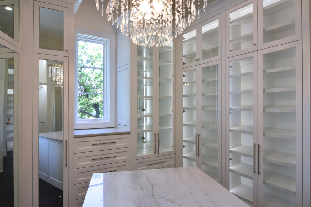This is an example of a large transitional women's walk-in wardrobe in Dallas with recessed-panel cabinets, white cabinets, medium hardwood floors and brown floor.