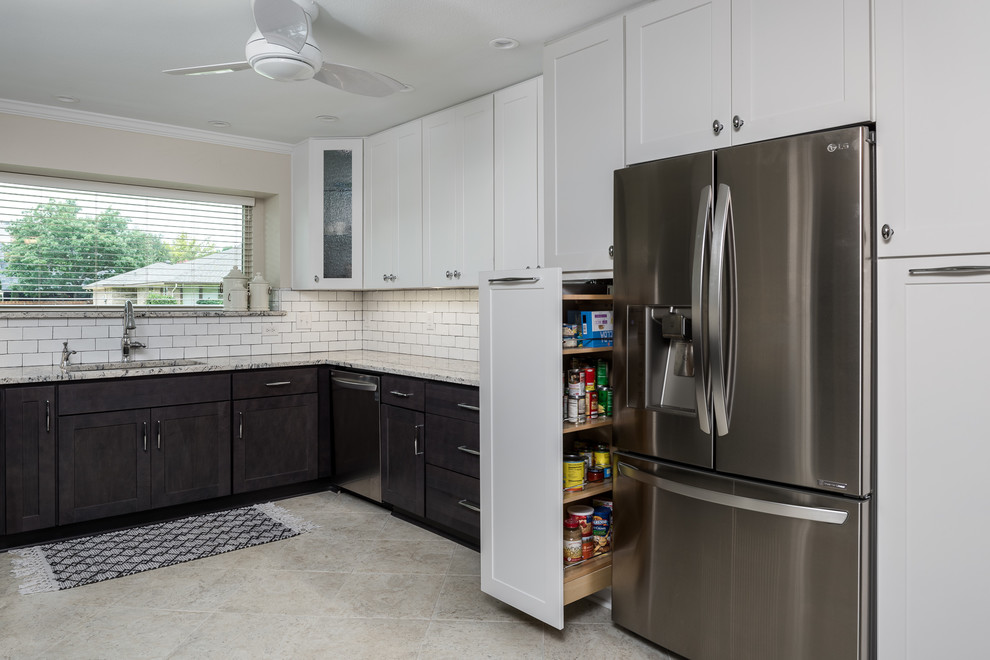 Design ideas for a mid-sized transitional u-shaped eat-in kitchen in Dallas with an undermount sink, glass-front cabinets, black cabinets, marble benchtops, white splashback, subway tile splashback, stainless steel appliances, porcelain floors, with island and white floor.