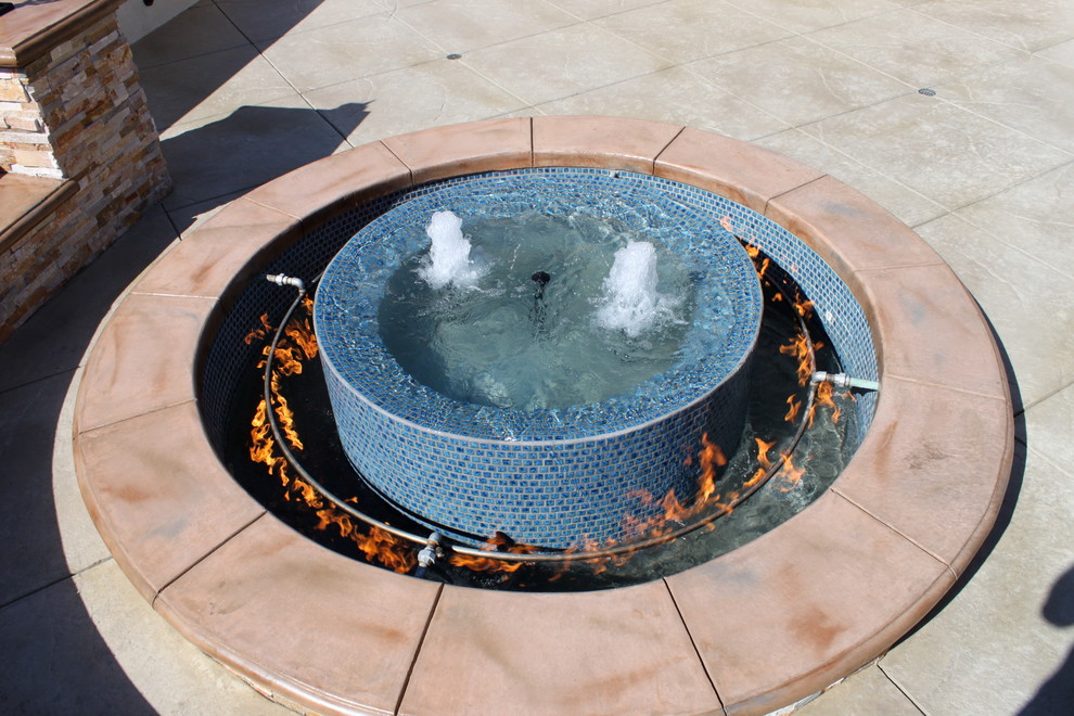 This is an example of a contemporary backyard patio in Los Angeles with a fire feature and stamped concrete.
