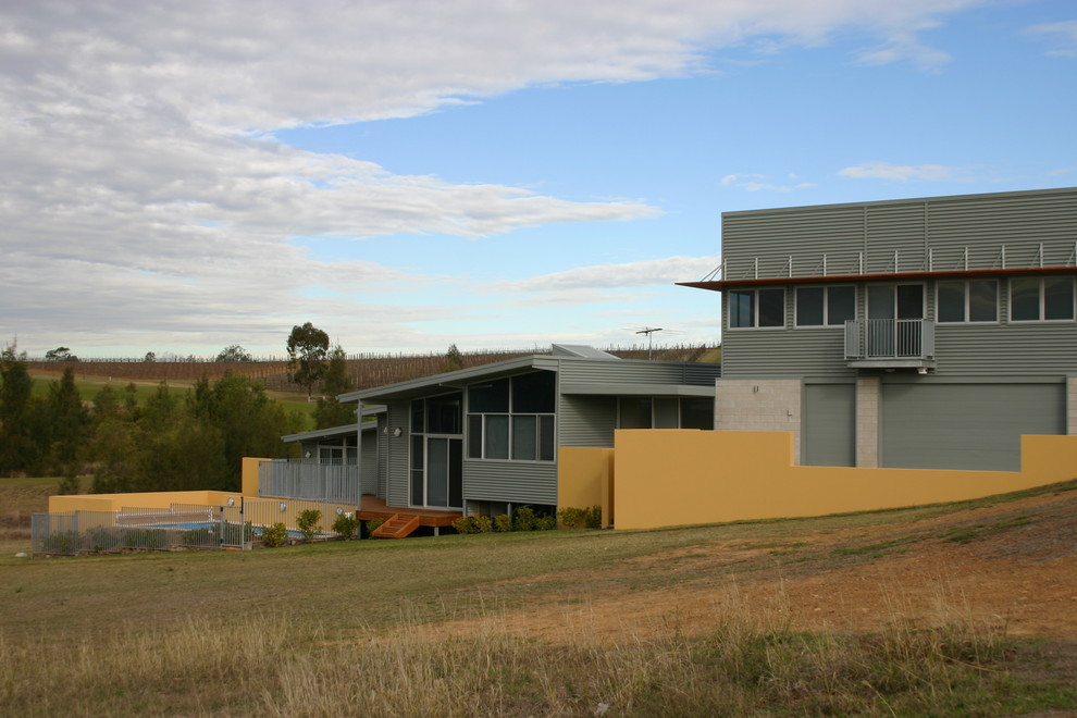Design ideas for a mid-sized industrial split-level grey exterior in Sydney with metal siding.