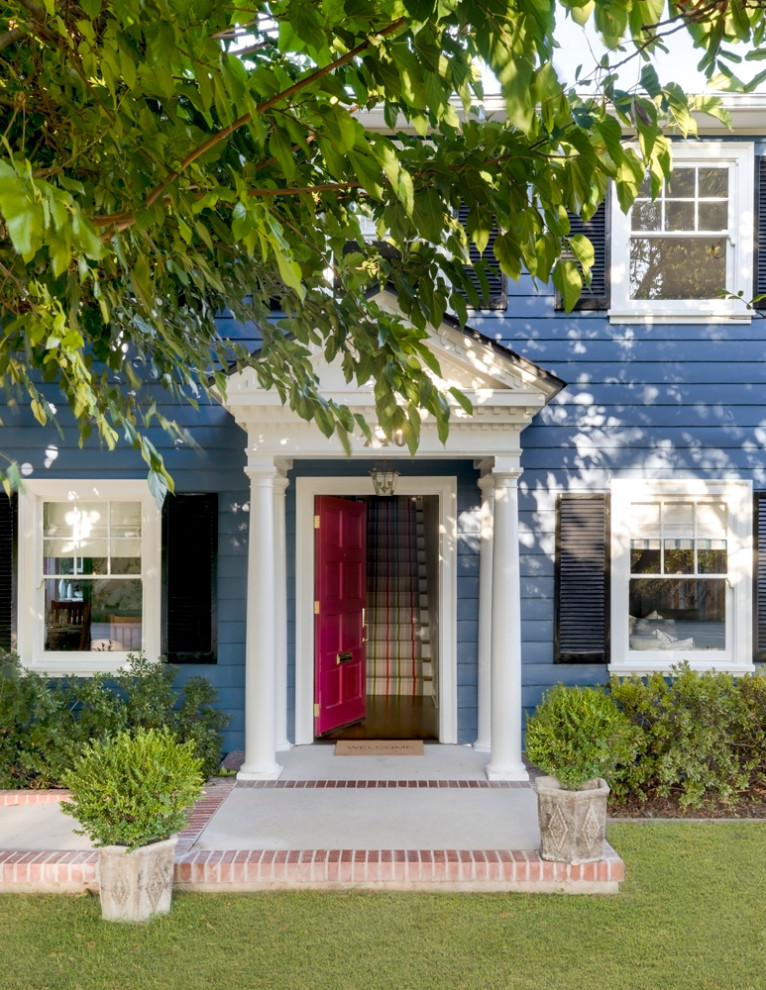 Réalisation d'une façade de maison bleue design en bois de taille moyenne et à un étage avec un toit à croupette et un toit blanc.