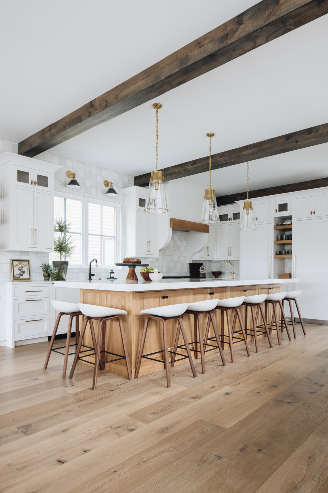 Kitchen - Kitchen - large coastal l-shaped light wood floor and exposed beam kitchen idea in Grand Rapids with white cabinets, quartzite countertops, white backsplash, ceramic backsplash, stainless steel appliances, an island and white countertops