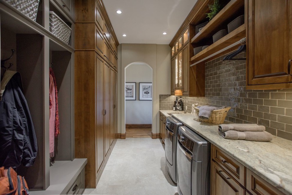 Inspiration for a large traditional galley utility room in Denver with an undermount sink, raised-panel cabinets, dark wood cabinets, granite benchtops, grey walls, concrete floors, a side-by-side washer and dryer and grey floor.