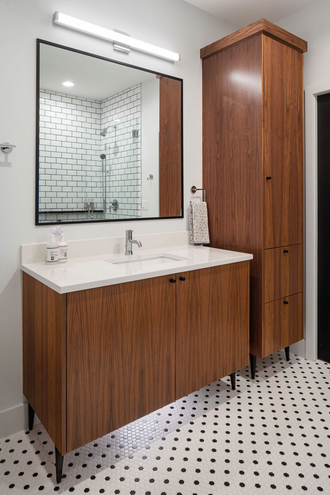 На фото: ванная комната среднего размера в современном стиле с плоскими фасадами, темными деревянными фасадами, душем в нише, белой плиткой, керамической плиткой, белыми стенами, полом из мозаичной плитки, душевой кабиной, врезной раковиной, столешницей из искусственного кварца, разноцветным полом, душем с распашными дверями, белой столешницей, сиденьем для душа, тумбой под одну раковину и напольной тумбой