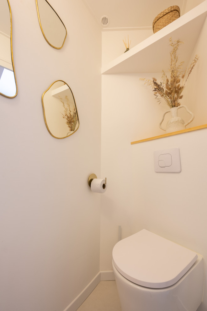 Пример оригинального дизайна: туалет в средиземноморском стиле с инсталляцией, бетонным полом и белым полом