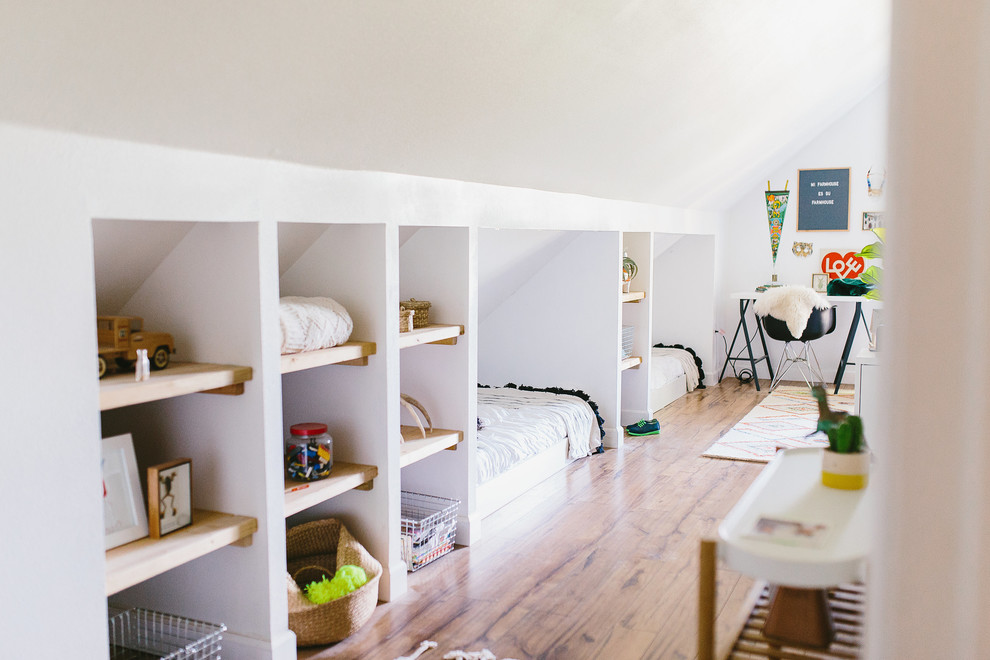 This is an example of a large country kids' bedroom in Other with white walls, laminate floors and brown floor.