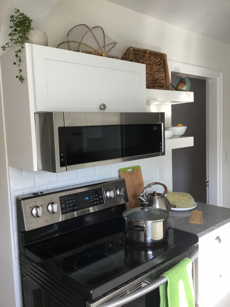 Example of a mid-sized transitional galley ceramic tile and gray floor eat-in kitchen design with an undermount sink, shaker cabinets, white cabinets, quartz countertops, white backsplash, subway tile backsplash, stainless steel appliances, a peninsula and gray countertops