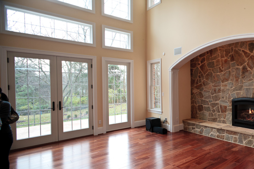 Inspiration for an expansive transitional open concept family room in DC Metro with medium hardwood floors and a stone fireplace surround.