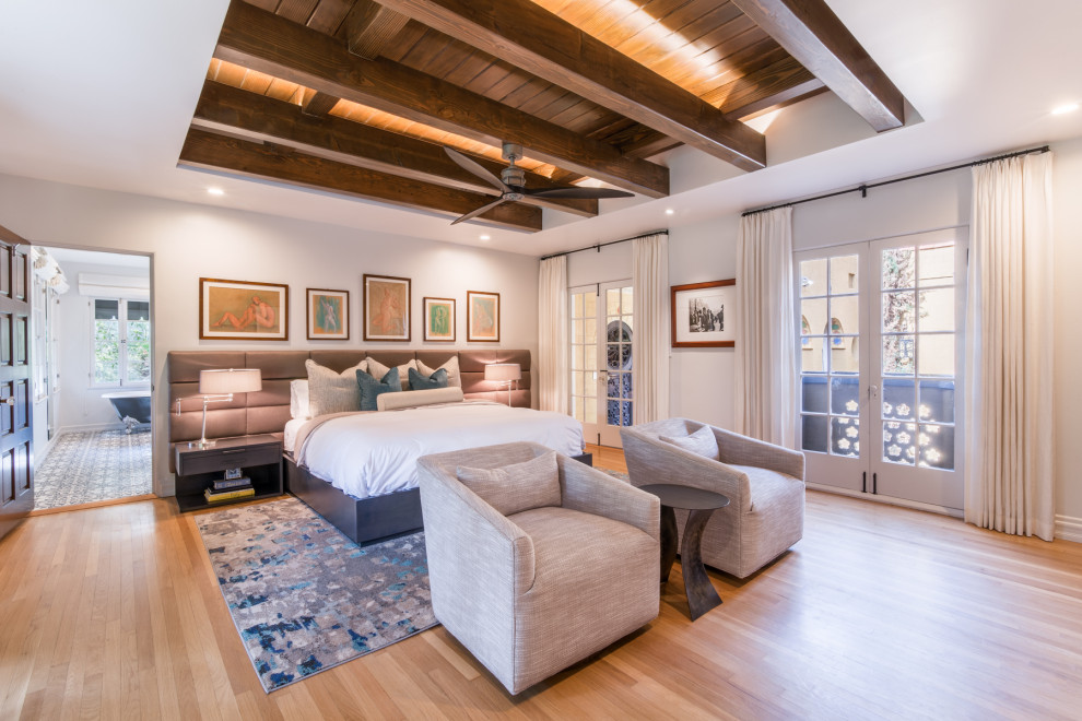 This is an example of a large transitional master bedroom in Los Angeles with beige walls, medium hardwood floors and brown floor.