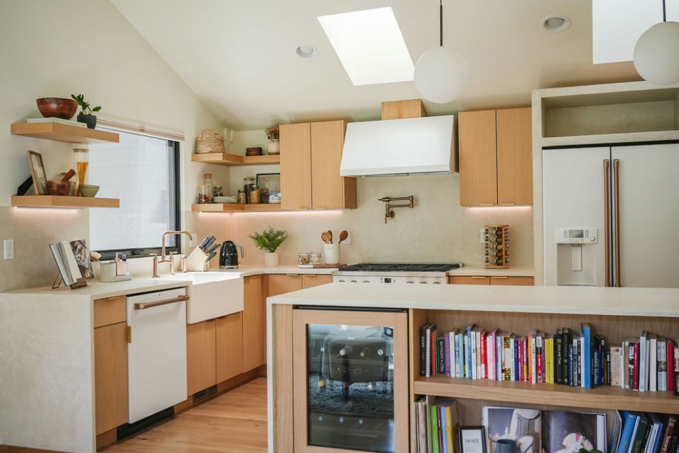 シアトルにあるアジアンスタイルのおしゃれなアイランドキッチン (エプロンフロントシンク、淡色木目調キャビネット、白いキッチンパネル、白い調理設備、淡色無垢フローリング、白いキッチンカウンター、三角天井) の写真