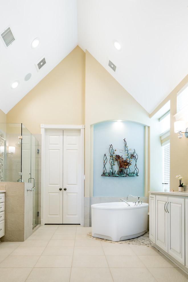 Photo of a large beach style master bathroom in Austin with a freestanding tub, yellow walls and ceramic floors.