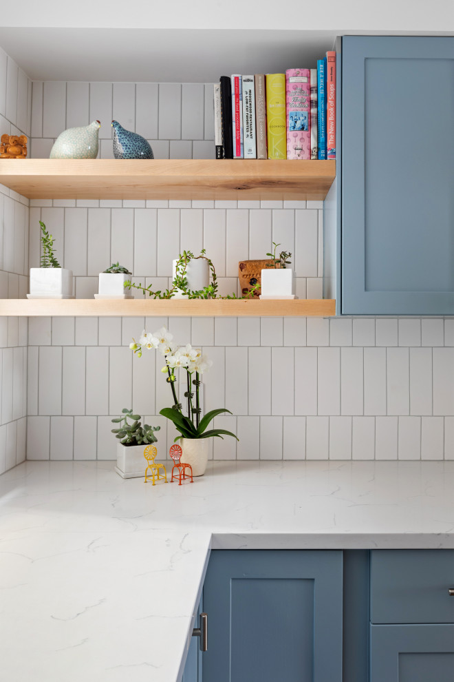 Idéer för mellanstora funkis vitt kök, med skåp i shakerstil, blå skåp, marmorbänkskiva, vitt stänkskydd, stänkskydd i keramik, rostfria vitvaror och en köksö