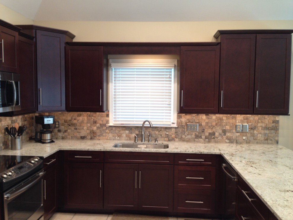 Example of a mid-sized transitional u-shaped ceramic tile enclosed kitchen design with an undermount sink, shaker cabinets, dark wood cabinets, wood countertops, beige backsplash, stone tile backsplash, stainless steel appliances and a peninsula