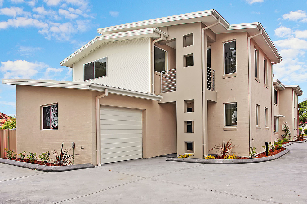 Photo of a mid-sized modern two-storey brick beige exterior in Newcastle - Maitland.