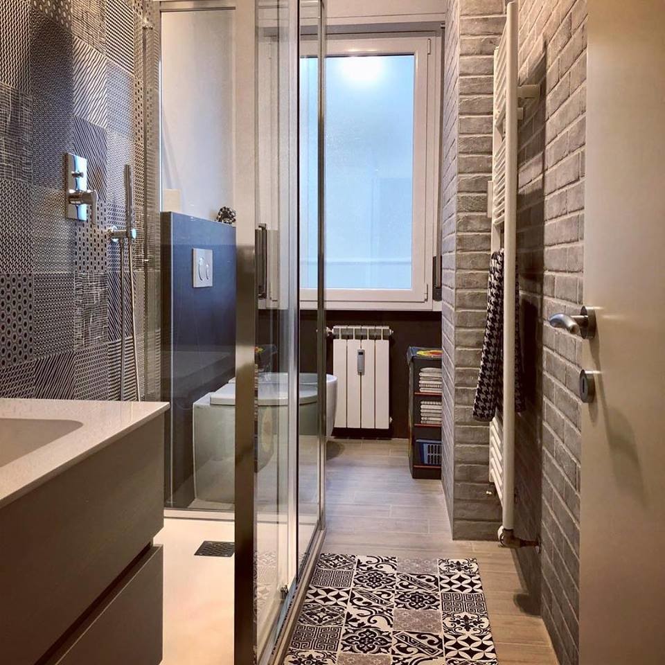 Small contemporary 3/4 bathroom in Other with light wood cabinets, a curbless shower, black tile, porcelain tile, porcelain floors, solid surface benchtops, grey floor, a sliding shower screen and white benchtops.