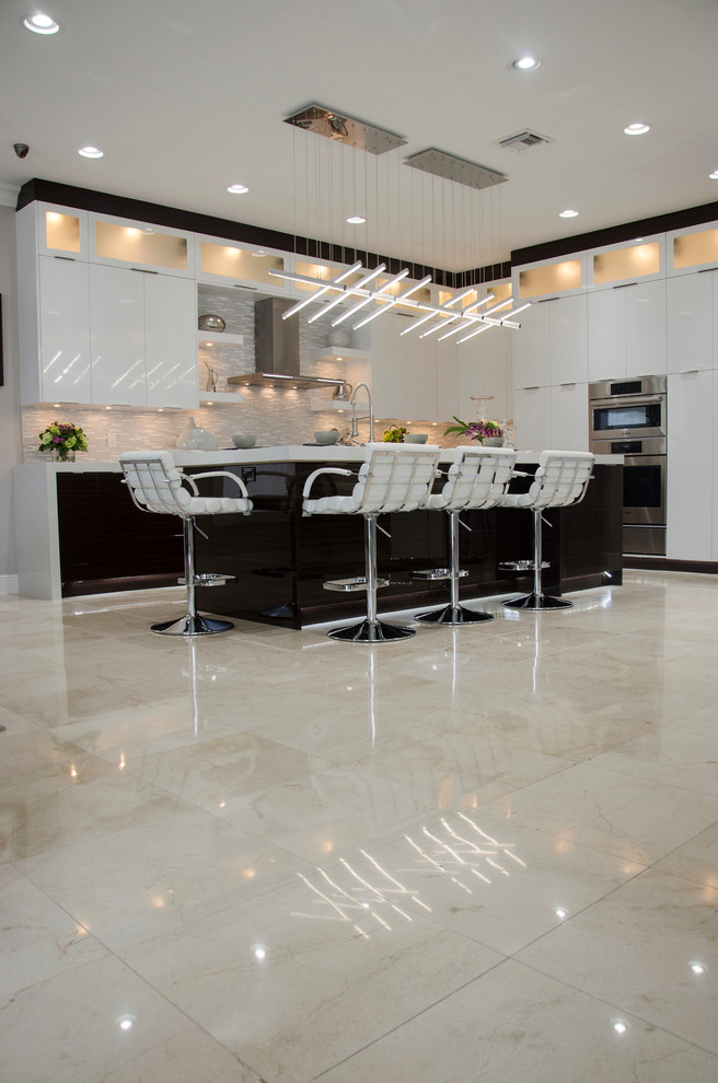 Design ideas for a large contemporary open plan kitchen in Miami with an undermount sink, flat-panel cabinets, white cabinets, quartz benchtops, multi-coloured splashback, mosaic tile splashback, stainless steel appliances, porcelain floors and with island.