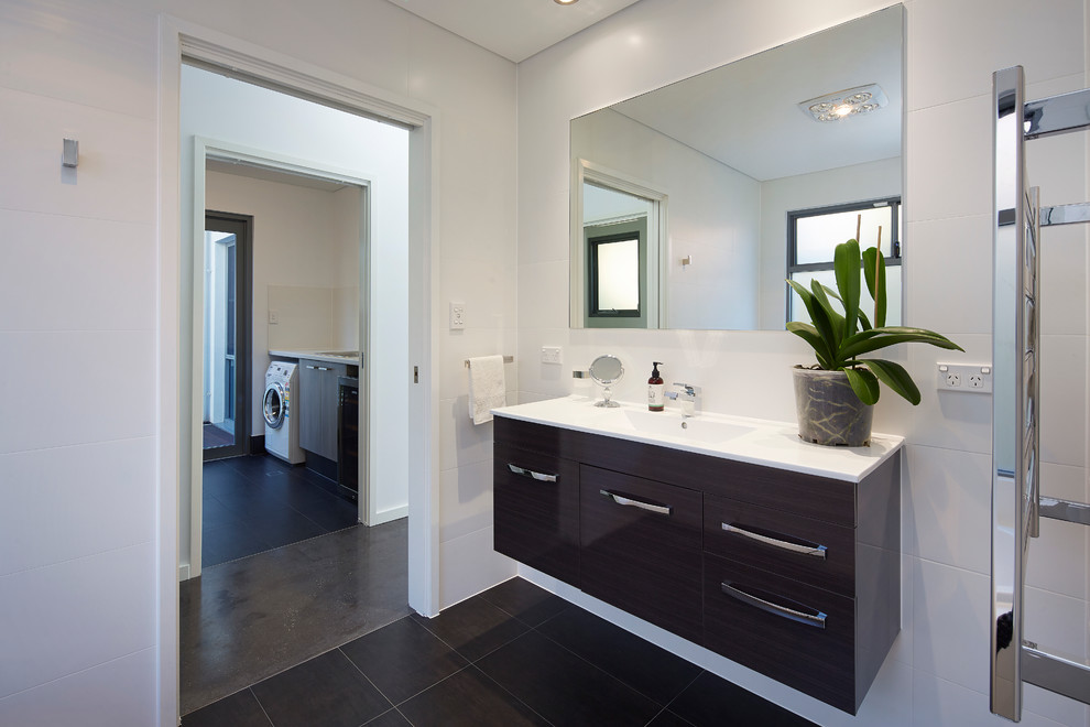 This is an example of a mid-sized contemporary 3/4 bathroom in Perth with an integrated sink, gray tile and white walls.