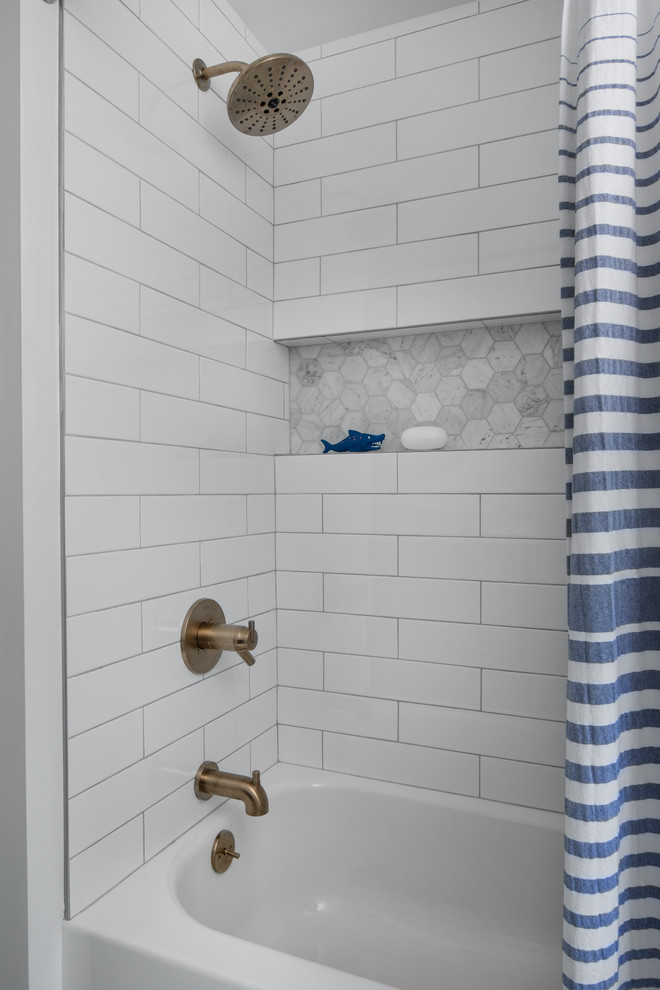 Photo of a mid-sized transitional kids bathroom in Detroit with beaded inset cabinets, blue cabinets, an alcove tub, a shower/bathtub combo, a two-piece toilet, white tile, subway tile, white walls, marble floors, an undermount sink, marble benchtops, grey floor, a shower curtain and grey benchtops.