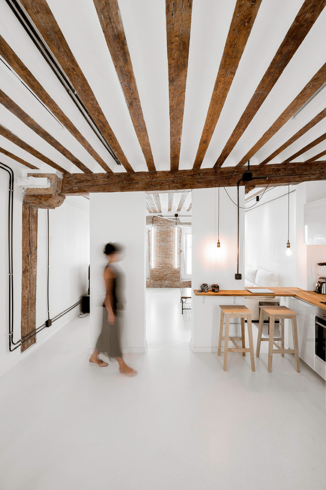 Photo of a medium sized industrial l-shaped open plan kitchen in Madrid with a submerged sink, brown splashback, wood splashback, white appliances, an island, white floors, brown worktops and exposed beams.