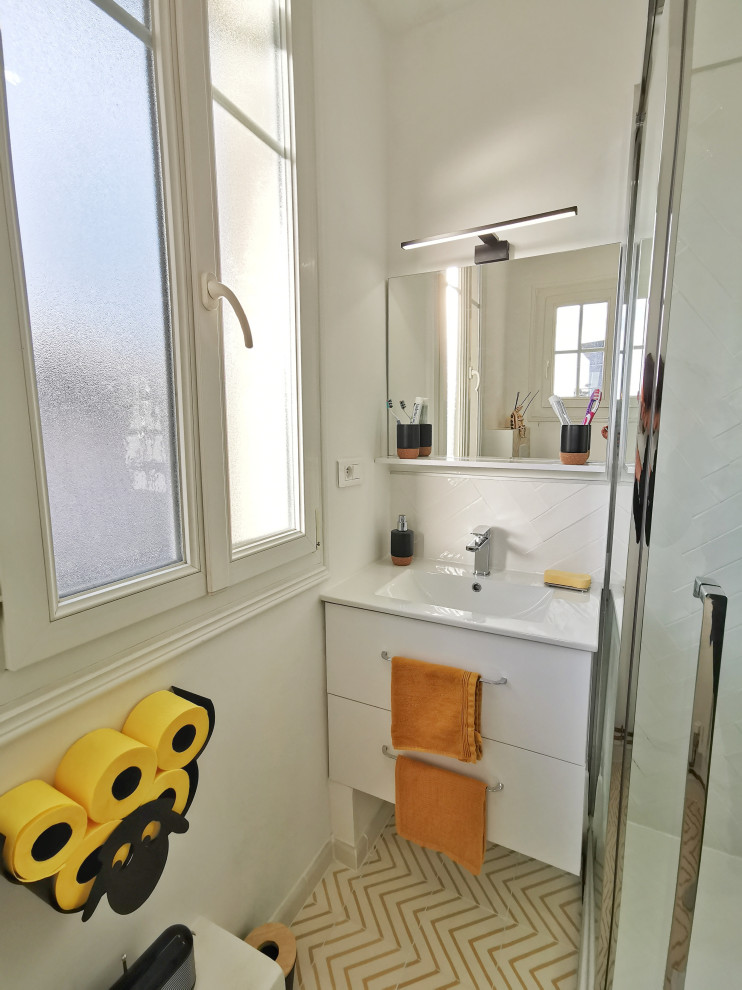 Réalisation d'une petite salle d'eau design avec un placard à porte plane, des portes de placard blanches, une douche double, WC suspendus, un carrelage blanc, des carreaux de céramique, un mur blanc, carreaux de ciment au sol, un lavabo encastré, un sol jaune, une cabine de douche à porte battante, un plan de toilette blanc, meuble simple vasque et meuble-lavabo suspendu.