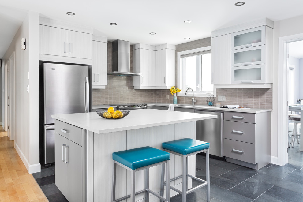 Design ideas for a mid-sized modern l-shaped eat-in kitchen in Ottawa with an undermount sink, flat-panel cabinets, grey cabinets, quartz benchtops, grey splashback, porcelain splashback, stainless steel appliances, slate floors, with island and black floor.