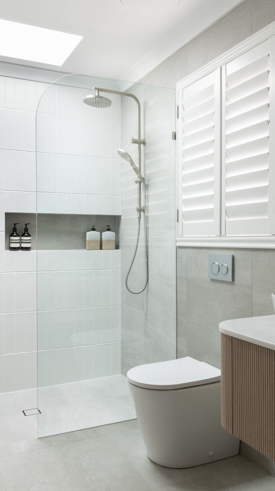 Mid-sized modern master bathroom in Perth with beaded inset cabinets, light wood cabinets, gray tile, ceramic tile, marble benchtops, white benchtops, a double vanity, a floating vanity, an open shower, a one-piece toilet, white walls, ceramic floors, a vessel sink, grey floor and a niche.