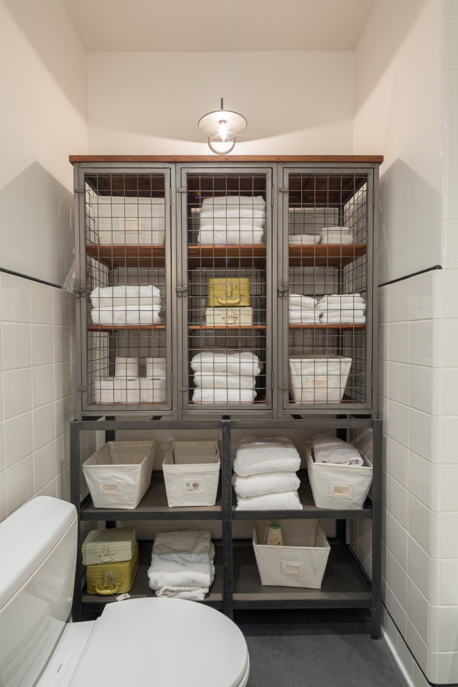 This is an example of a mid-sized traditional kids bathroom in San Francisco with furniture-like cabinets, an alcove tub, a shower/bathtub combo, a one-piece toilet, white tile, ceramic tile, white walls, concrete floors and black floor.