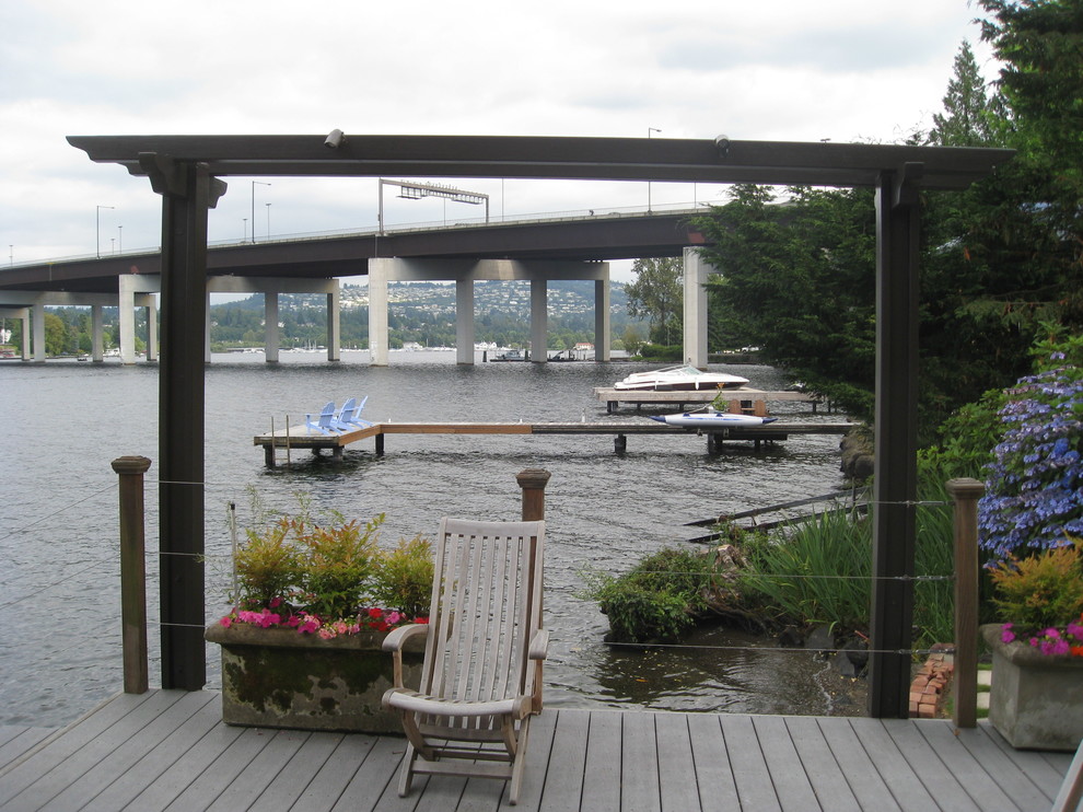 This is an example of a mid-sized traditional backyard deck in Seattle with with dock and a pergola.