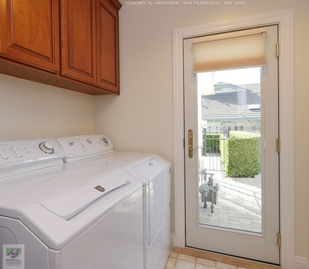 Mid-sized single-wall dedicated laundry room in San Francisco with medium wood cabinets, beige walls, ceramic floors, a side-by-side washer and dryer, beige floor and vaulted.