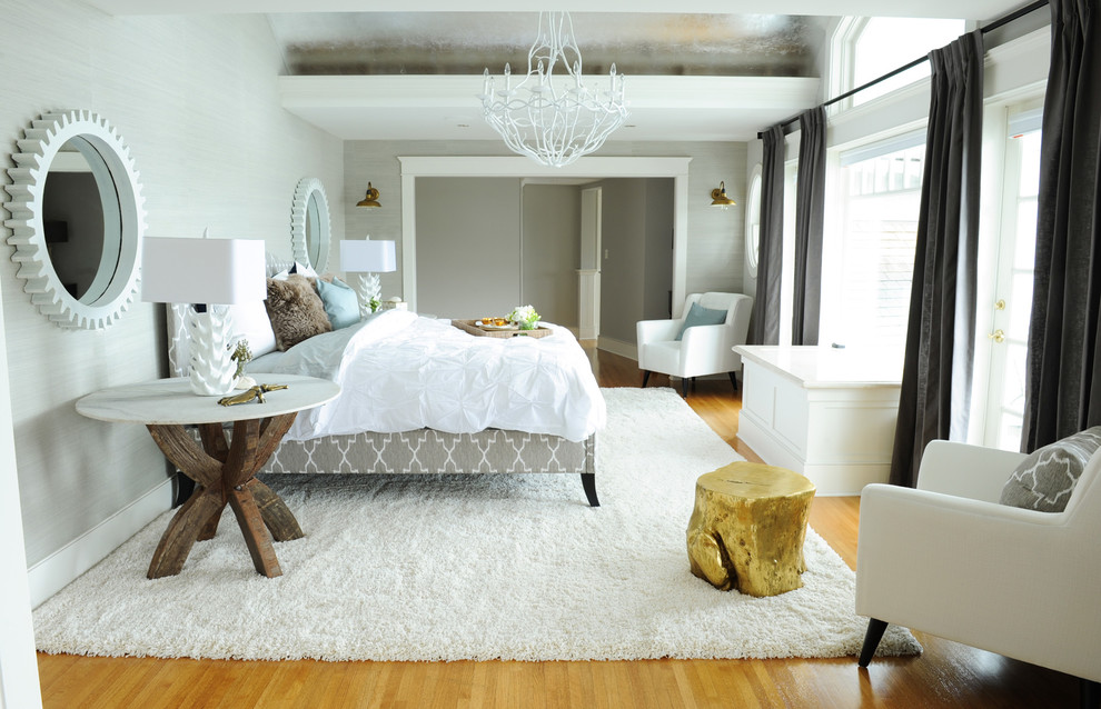 Photo of a large beach style master bedroom in Vancouver with grey walls and light hardwood floors.