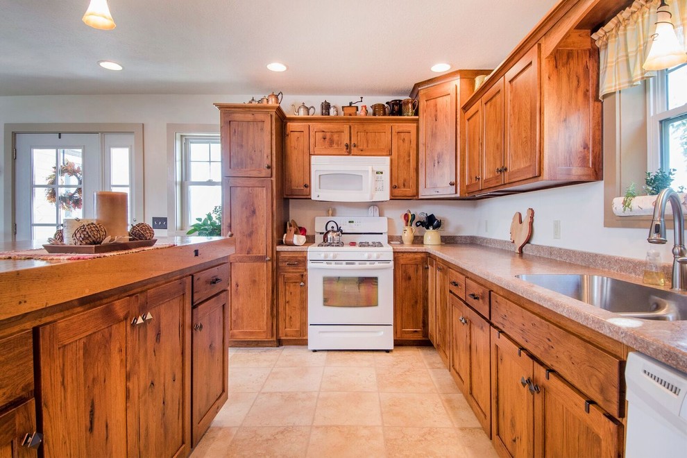 Example of a mid-sized mountain style u-shaped laminate floor eat-in kitchen design in Cincinnati with a drop-in sink, recessed-panel cabinets, medium tone wood cabinets, wood countertops, white appliances, an island and brown countertops