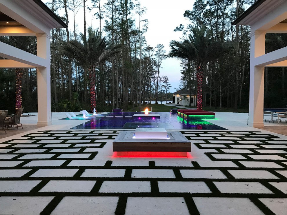 Design ideas for an expansive modern backyard custom-shaped infinity pool in Orlando with a water feature.