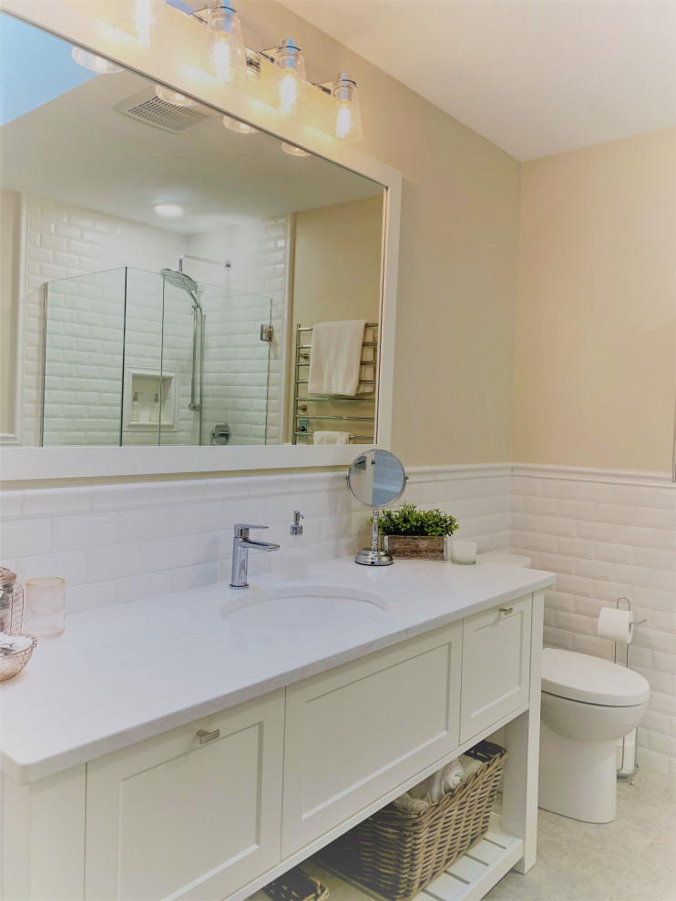 Идея дизайна: главная ванная комната среднего размера в морском стиле с фасадами в стиле шейкер, белыми фасадами, накладной ванной, угловым душем, унитазом-моноблоком, белой плиткой, плиткой кабанчик, желтыми стенами, врезной раковиной, столешницей из искусственного кварца, душем с распашными дверями, белой столешницей, тумбой под одну раковину, напольной тумбой и панелями на стенах