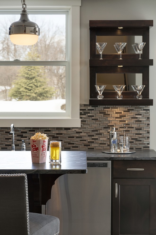 Photo of a mid-sized transitional single-wall seated home bar in Minneapolis with an undermount sink, shaker cabinets, dark wood cabinets, soapstone benchtops, multi-coloured splashback, matchstick tile splashback and dark hardwood floors.