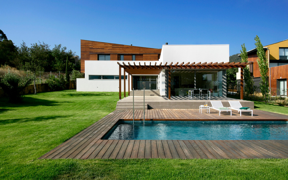 This is an example of a large modern two-storey brown exterior in Barcelona with mixed siding and a flat roof.