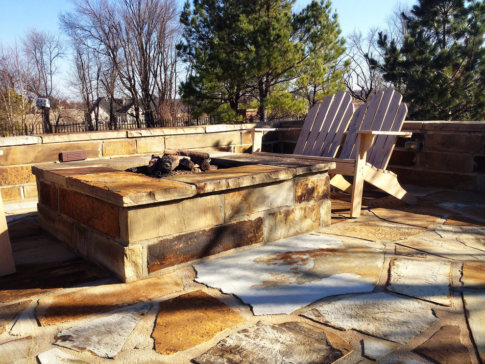 Traditional backyard patio in Other with a fire feature, natural stone pavers and no cover.
