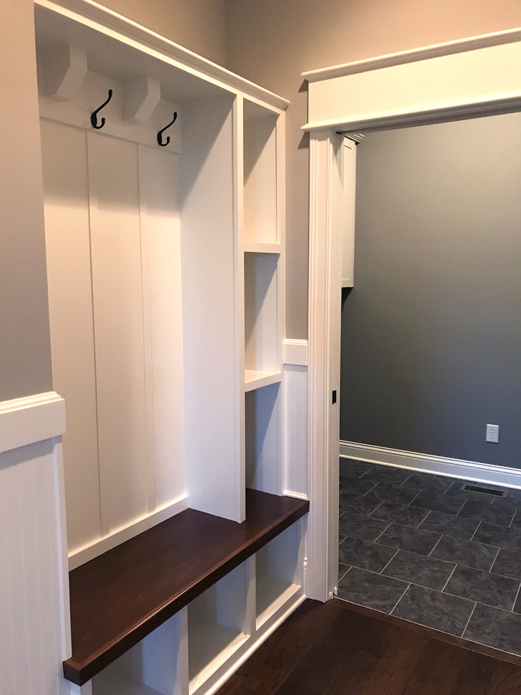 Photo of a mid-sized arts and crafts hallway in Indianapolis with grey walls, dark hardwood floors and brown floor.