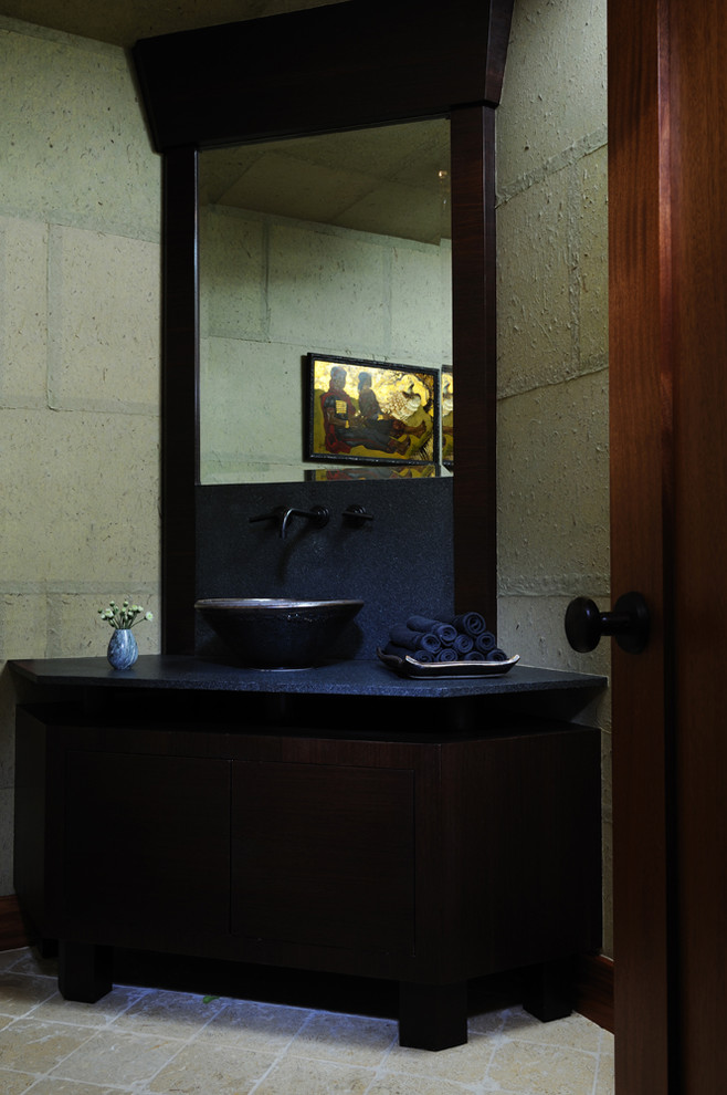 This is an example of a mid-sized contemporary powder room in Los Angeles with flat-panel cabinets, dark wood cabinets, grey walls, cement tiles, a vessel sink and laminate benchtops.