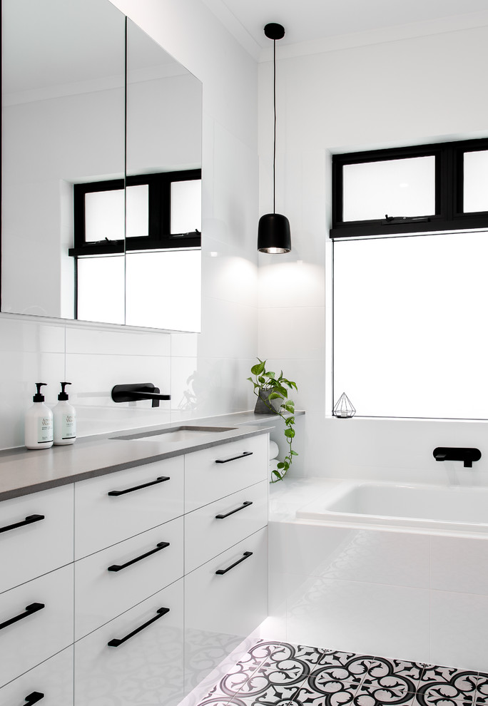 Photo of a large contemporary bathroom in Adelaide with a drop-in tub, a corner shower, white tile, ceramic tile, white walls, ceramic floors, black floor and a hinged shower door.