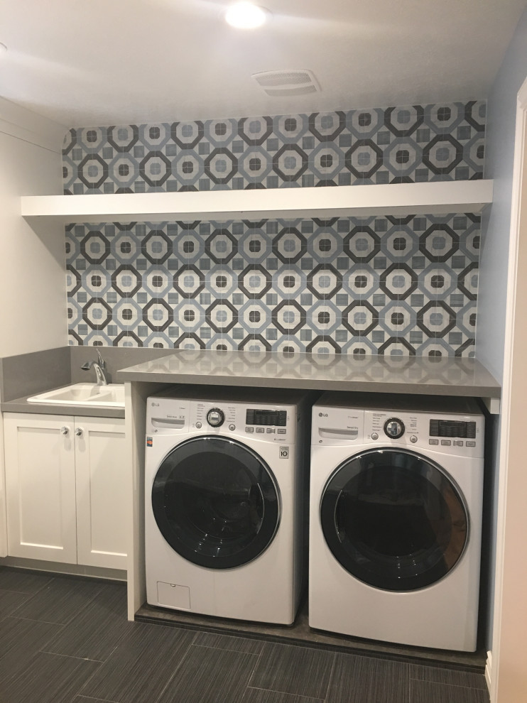 Design ideas for a mid-sized traditional u-shaped dedicated laundry room in Salt Lake City with a double-bowl sink, recessed-panel cabinets, white cabinets, quartz benchtops, white walls, ceramic floors, a side-by-side washer and dryer, grey floor and grey benchtop.