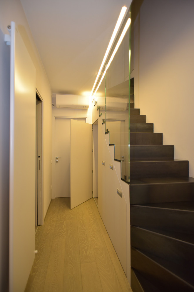 Esempio di una lavanderia minimalista di medie dimensioni con pareti bianche, pavimento in legno massello medio e pavimento marrone