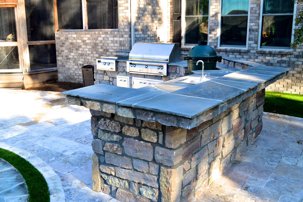 Inspiration for a mid-sized industrial backyard patio in Nashville with an outdoor kitchen, natural stone pavers and no cover.