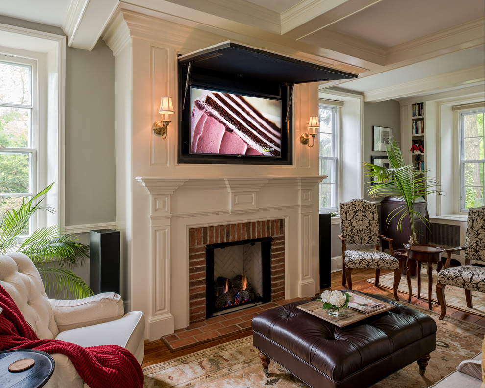 Design ideas for a small traditional formal enclosed living room in Philadelphia with grey walls, medium hardwood floors, a standard fireplace, a brick fireplace surround and a concealed tv.
